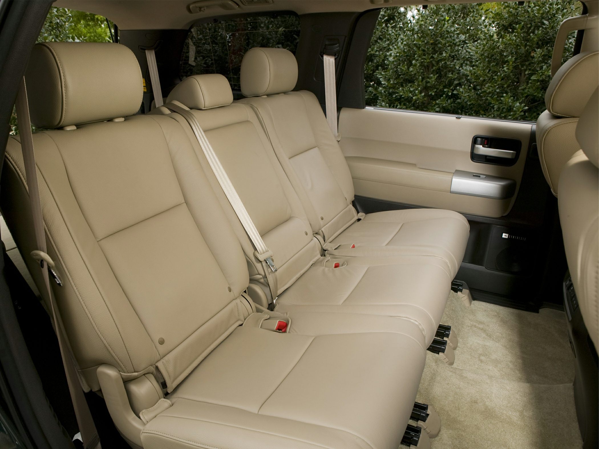Beige leather rear seats interior with seat belts and door panel