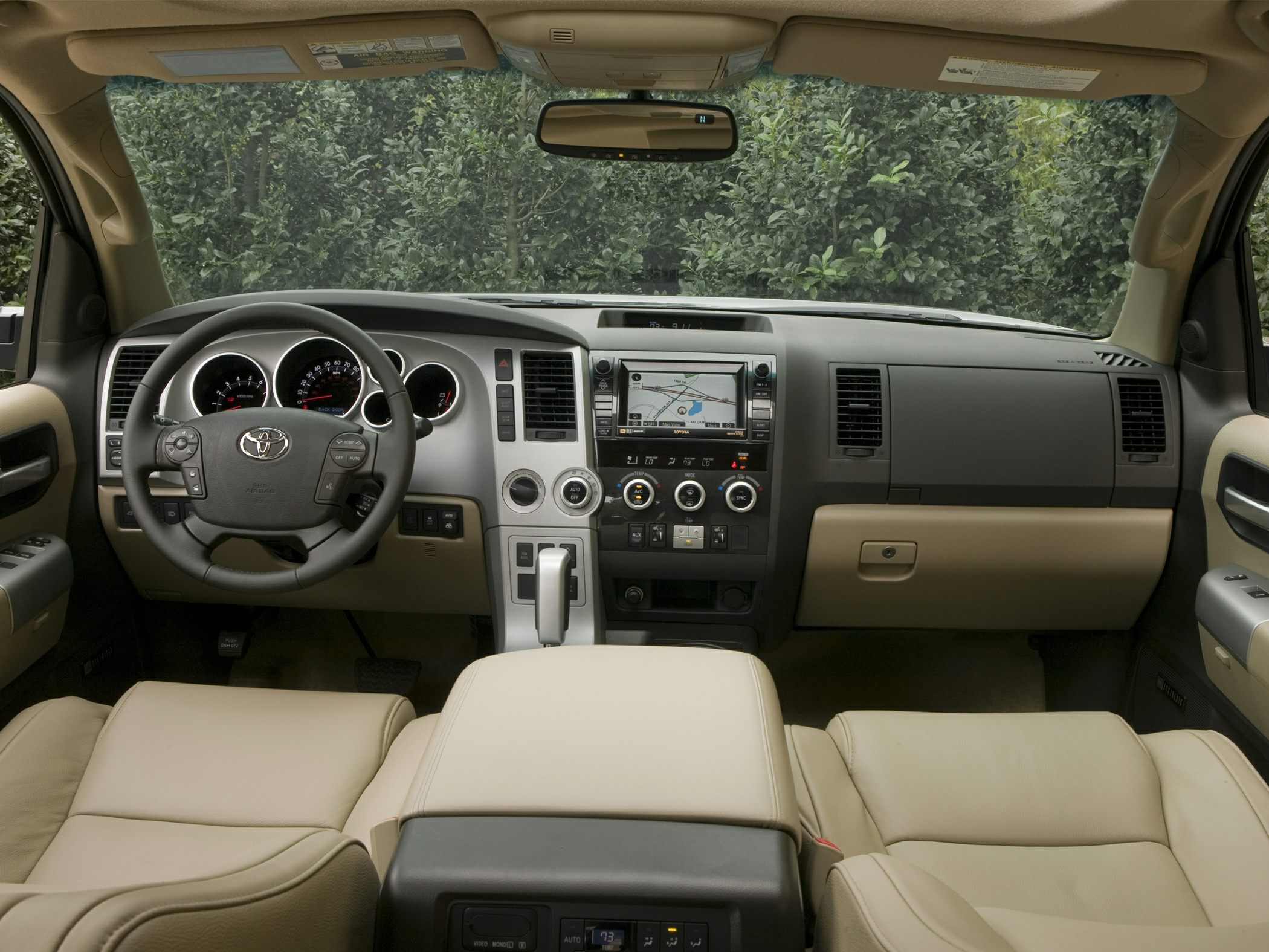 Dashboard and steering wheel with navigation system in beige and black interior