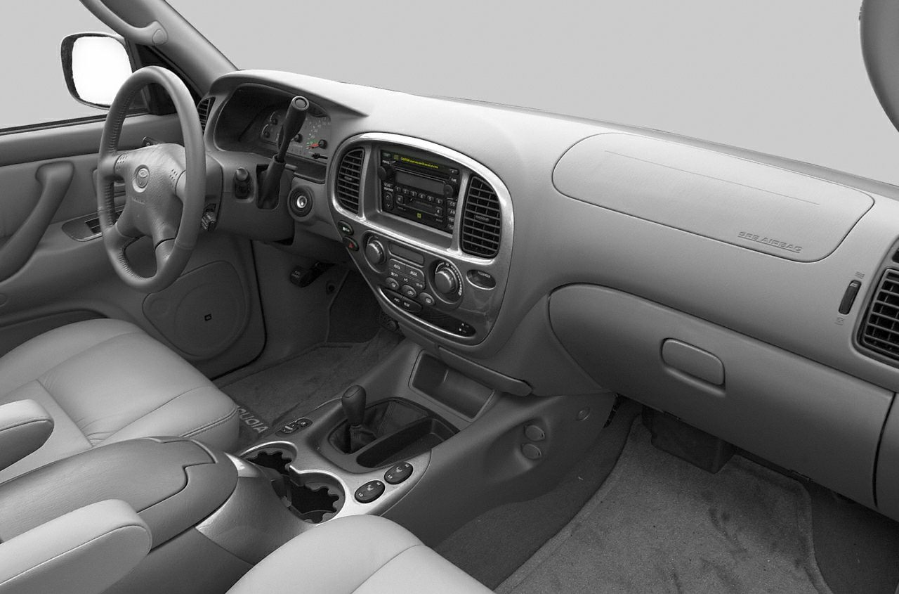 Dashboard, steering wheel, and center console with controls and cup holders