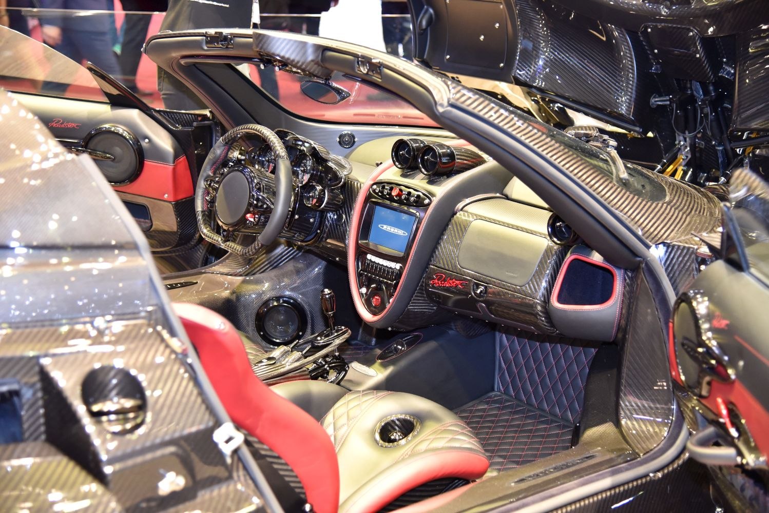 Luxury carbon fiber sports car interior with red accents and advanced dashboard