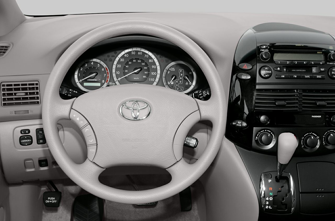 Car interior with steering wheel, dashboard, and central gear shifter