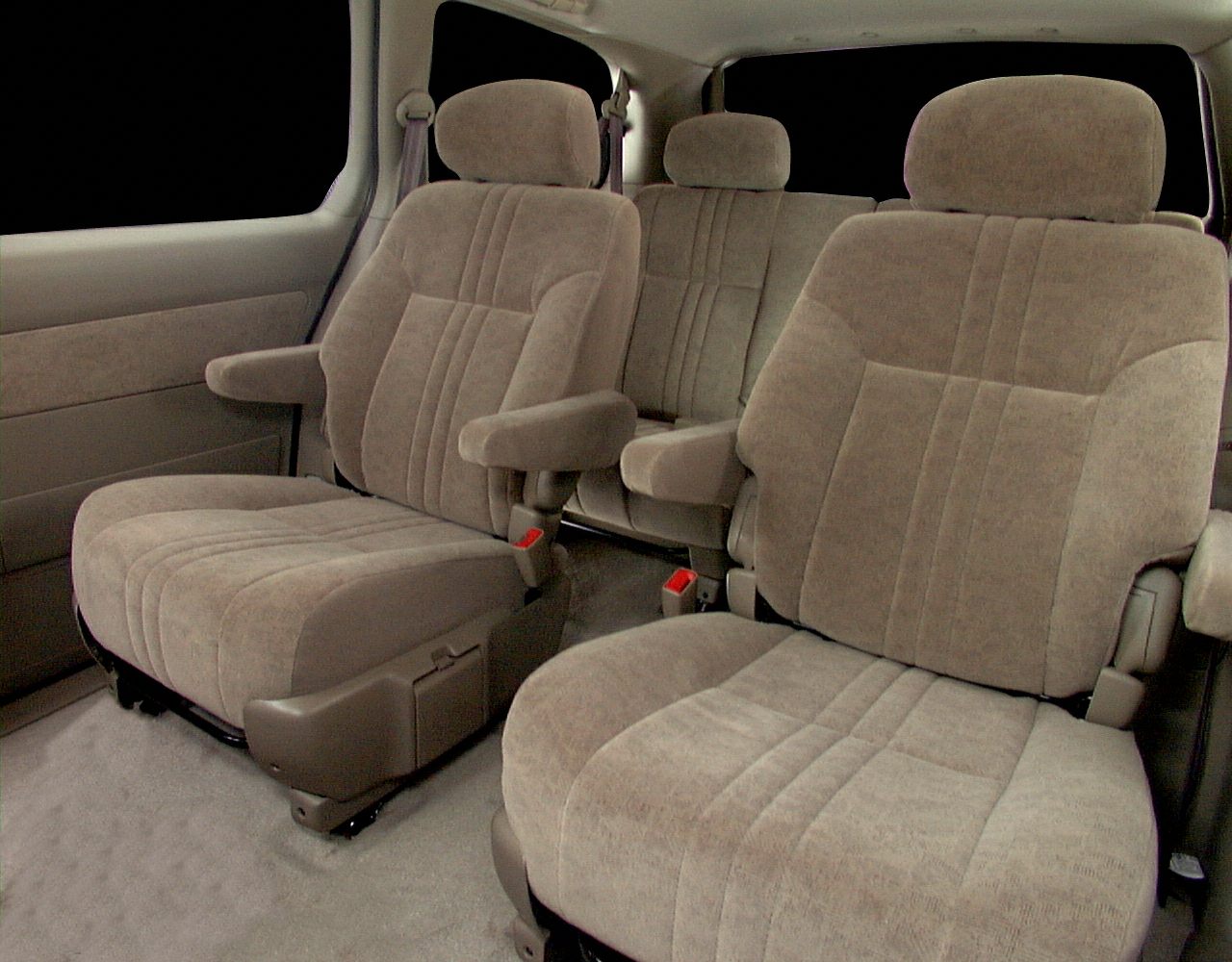 Plush spacious minivan seats with individual armrests and beige upholstery