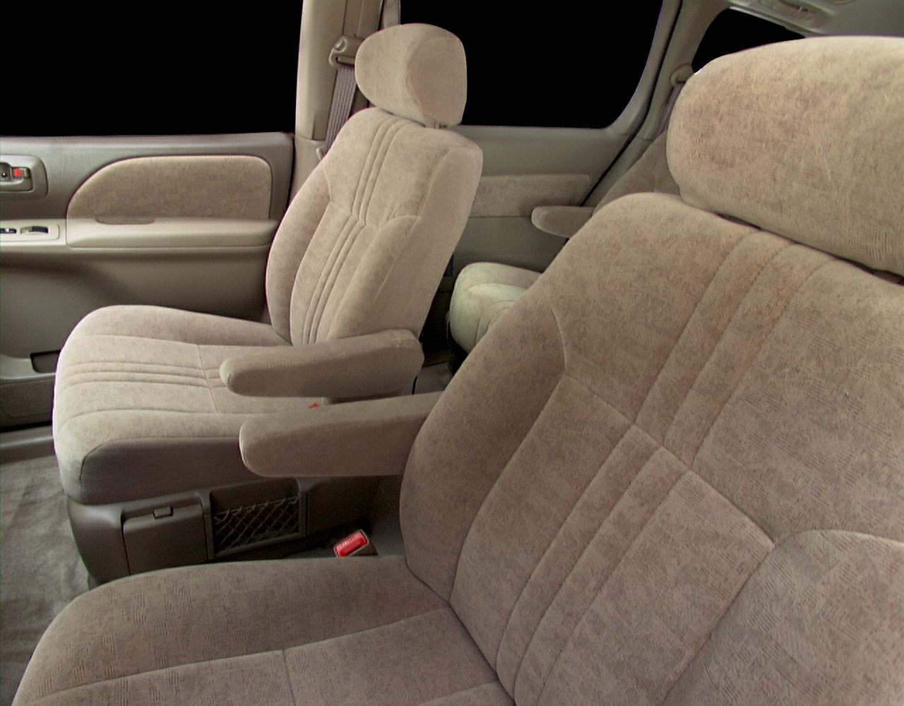 Beige upholstered front seats with armrests and detailed stitching