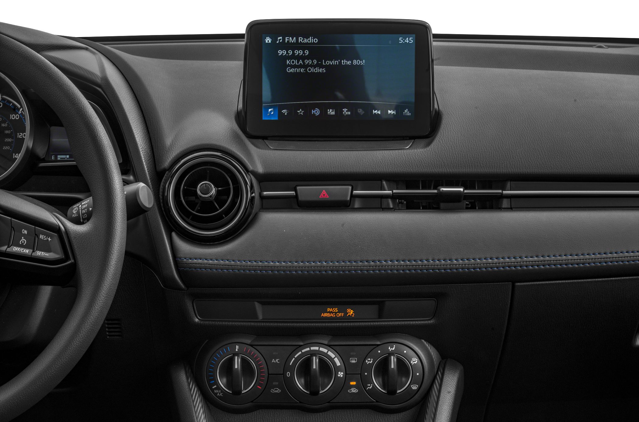 Dashboard interior with infotainment screen, circular vent, manual climate controls