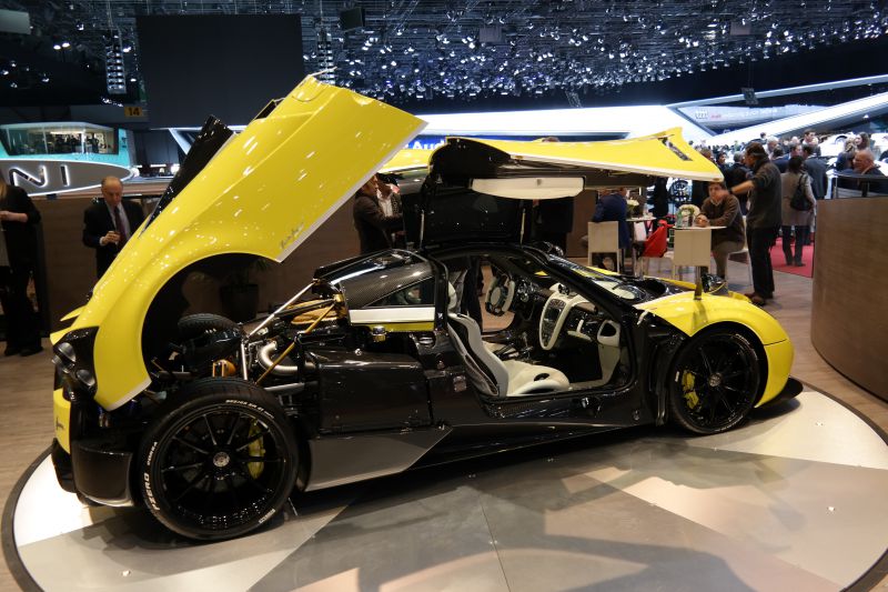 Gullwing doors open with exposed rear engine and visible interior