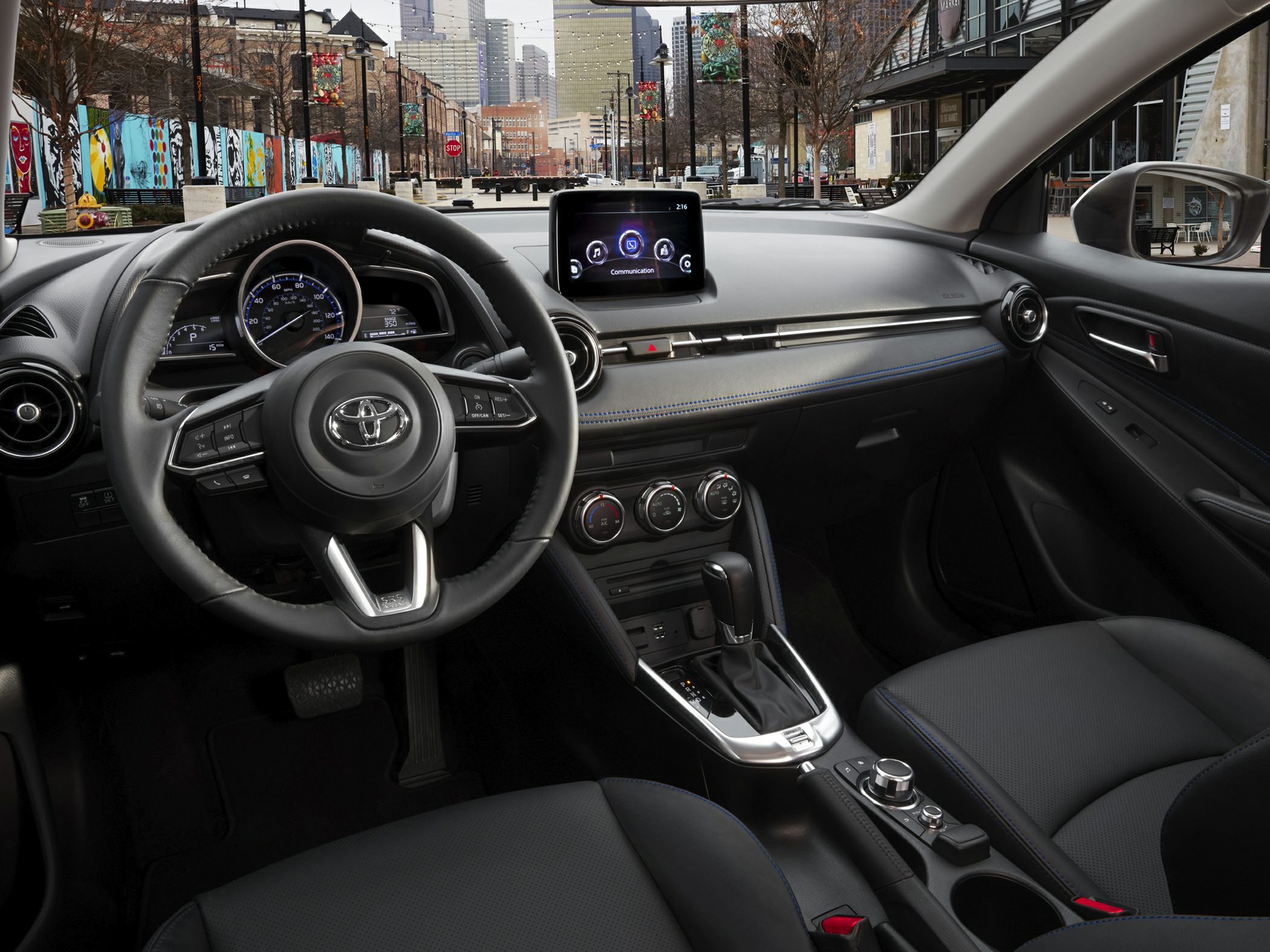 Dashboard, steering wheel, touchscreen, and center console details in compact car interior