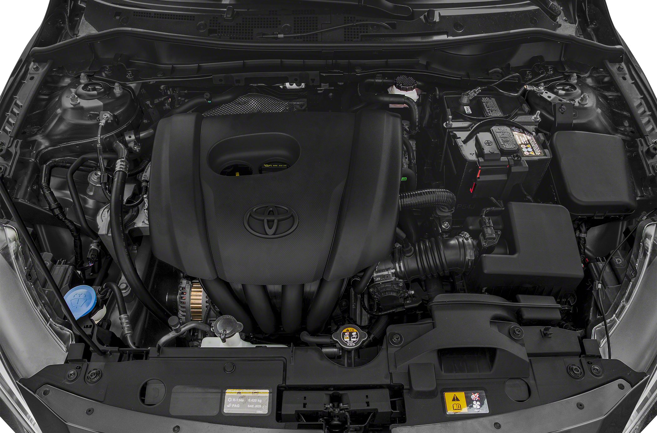 Engine bay with Toyota emblem on engine cover and visible mechanical components