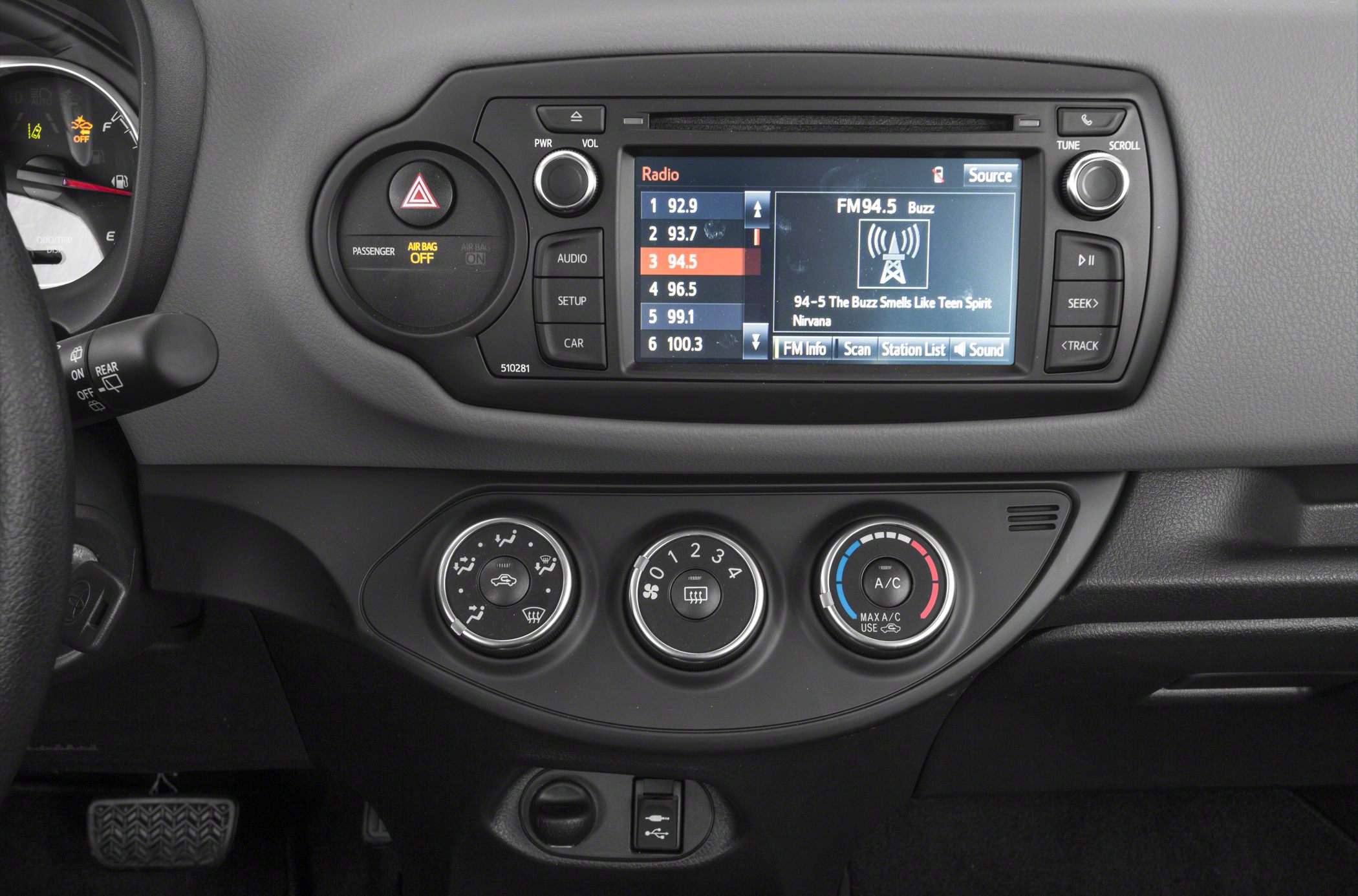 Car dashboard with infotainment screen and manual climate controls