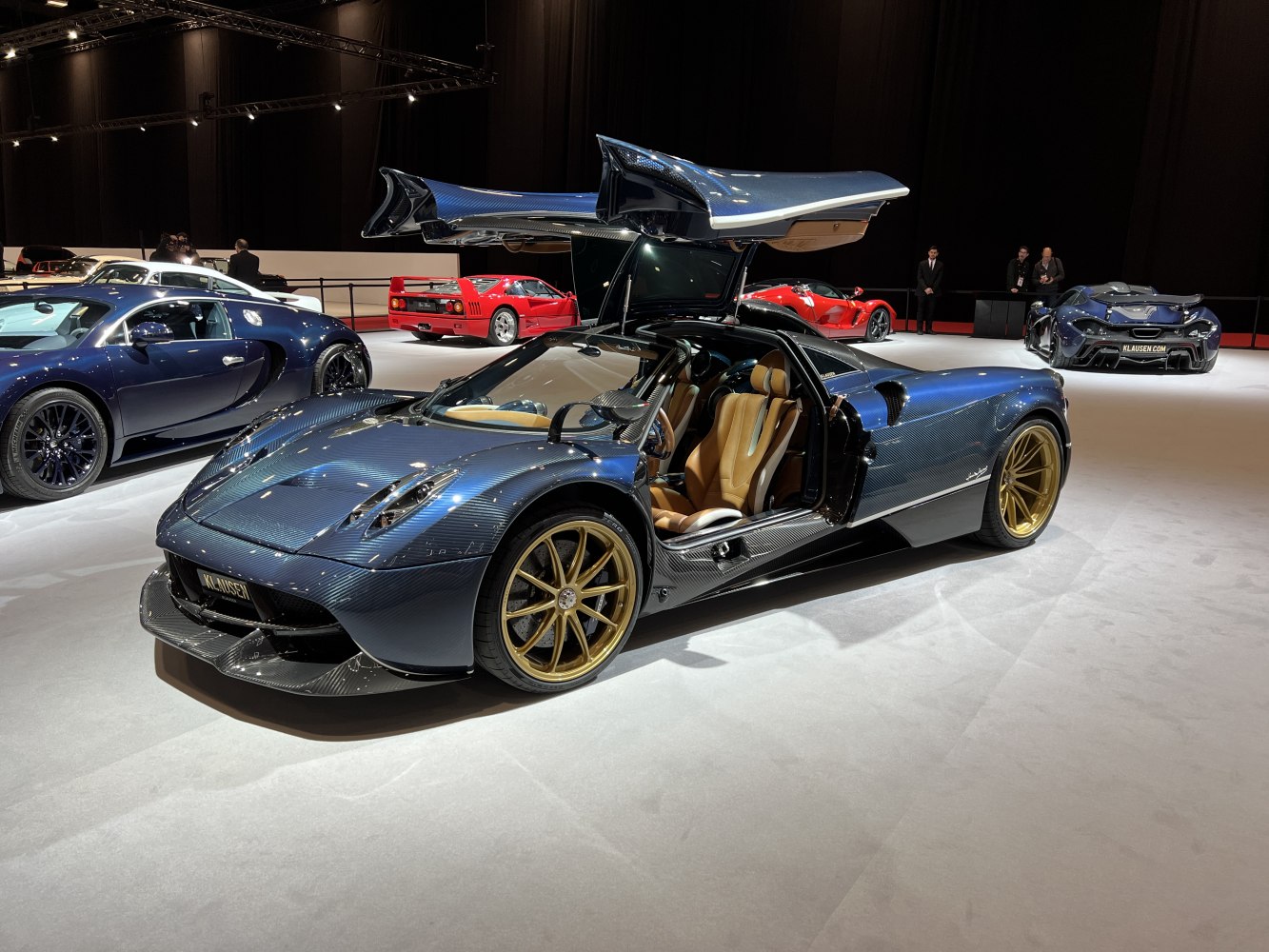 Gullwing doors open on carbon fiber-bodied sports car with golden rims