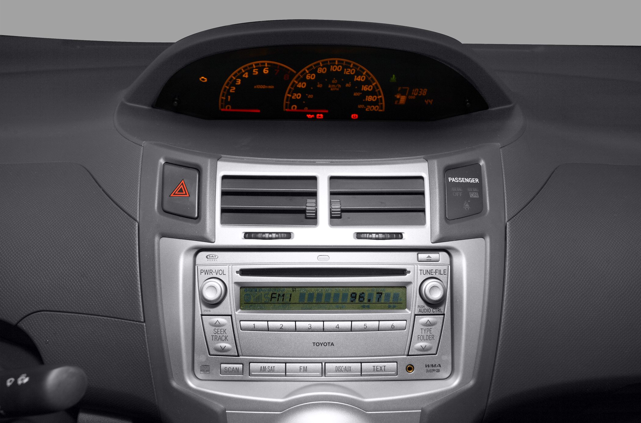 Dashboard instrument cluster with digital and analog displays, central air vents, and radio controls