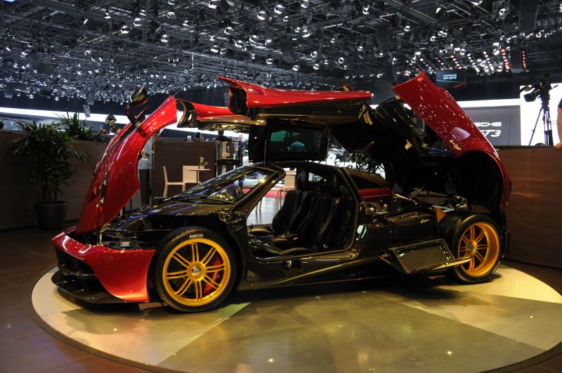 Luxury sports coupe with gullwing doors and golden wheels