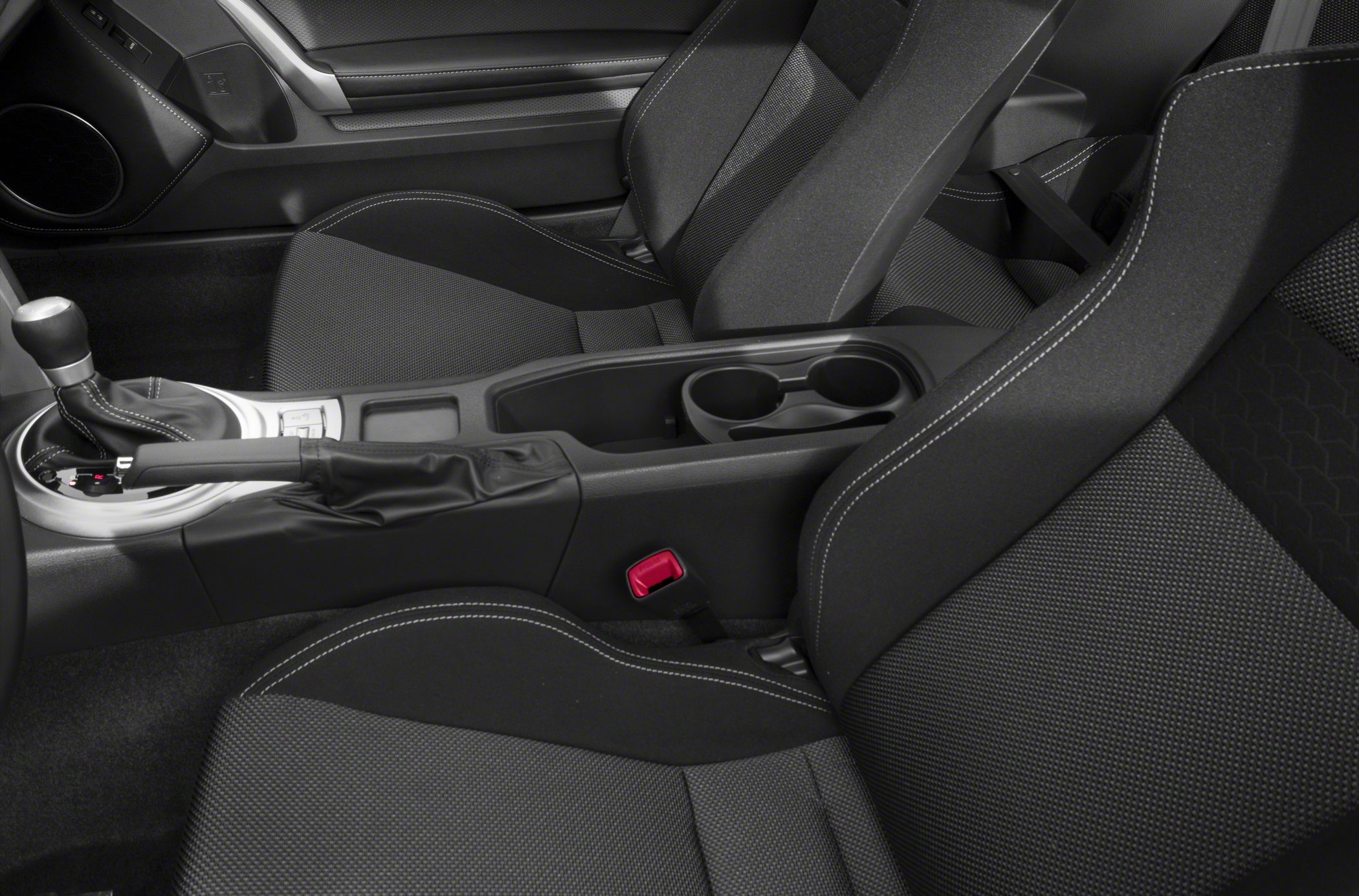 Close-up of front seats and center console with gear shift and cup holders