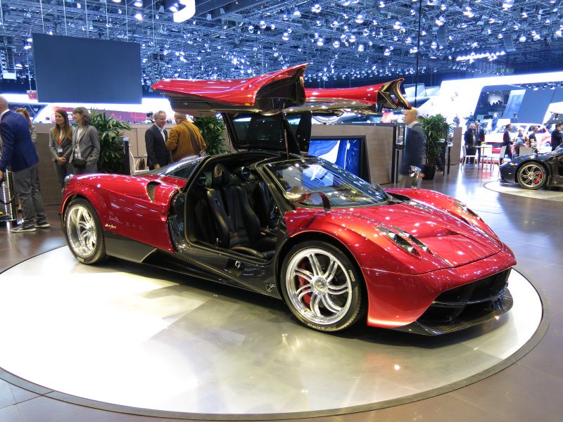 Red luxury sports car with open gullwing doors and aerodynamic design