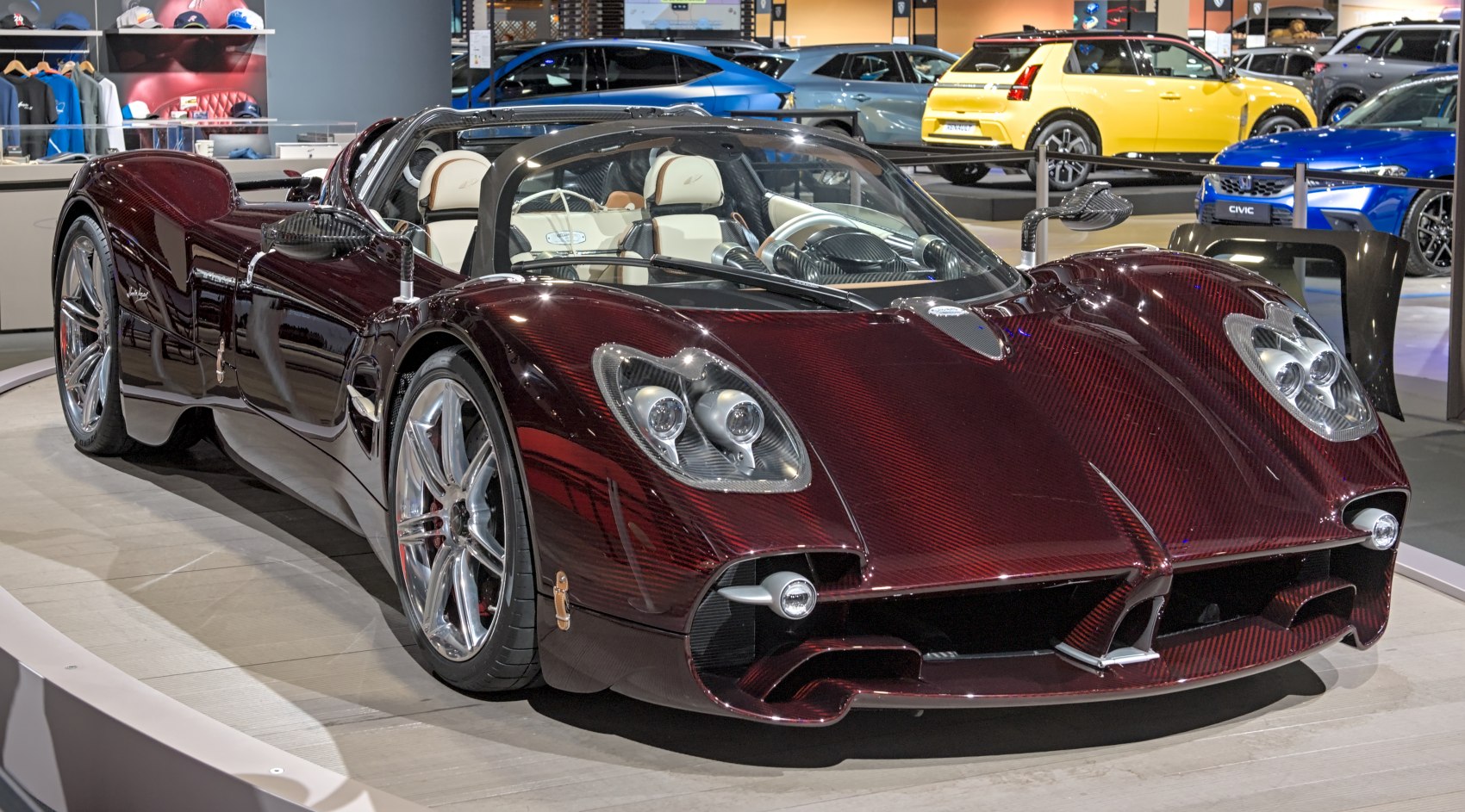 Exotic open-top supercar with carbon fiber body and distinctive front headlights.