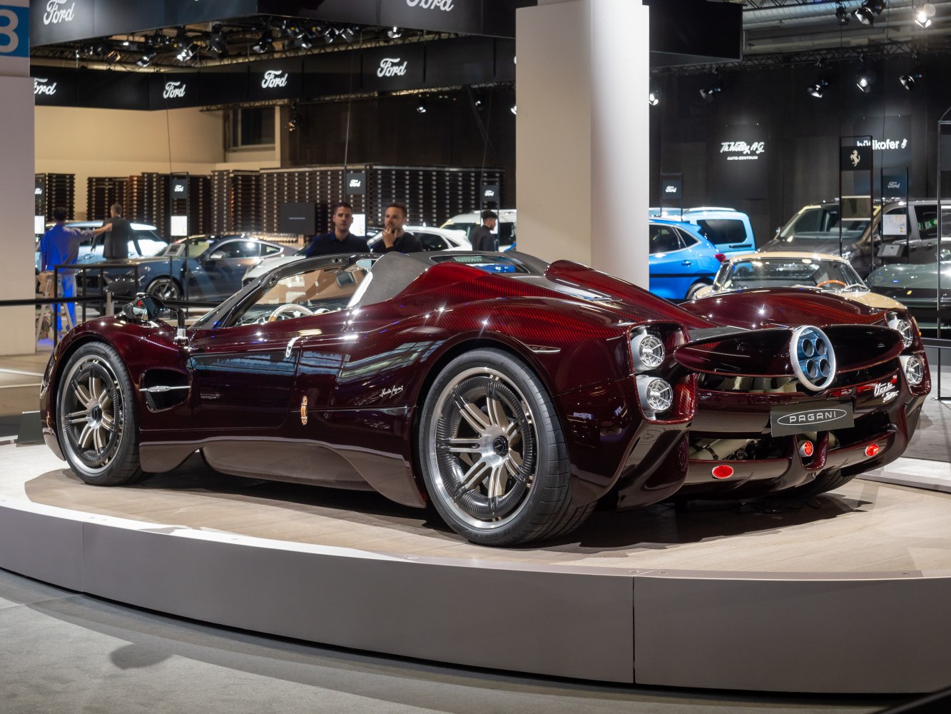 Rear view of luxury open-top supercar with quad exhaust tips.