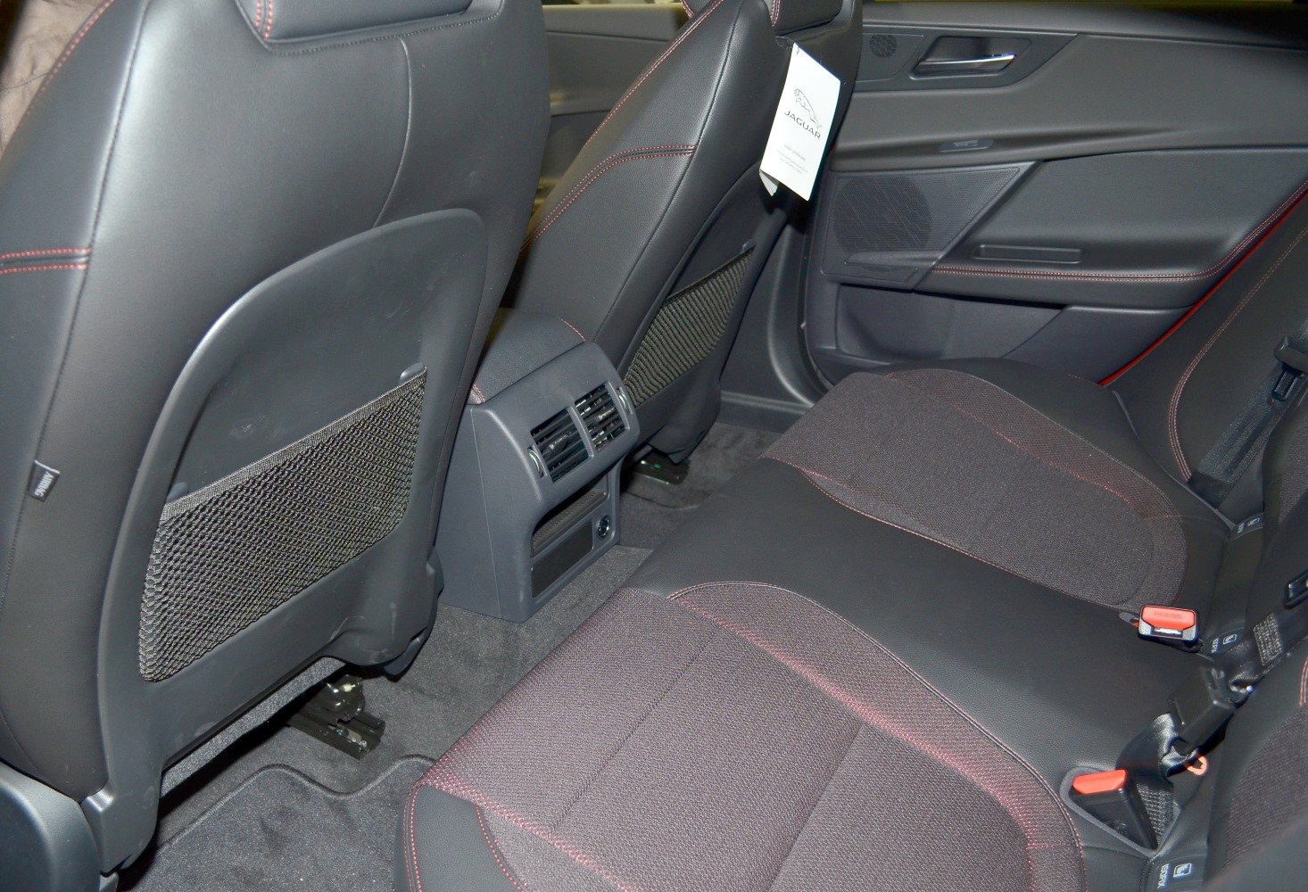 Rear seat with fabric and leather upholstery, rear air vents, and seatback storage pockets