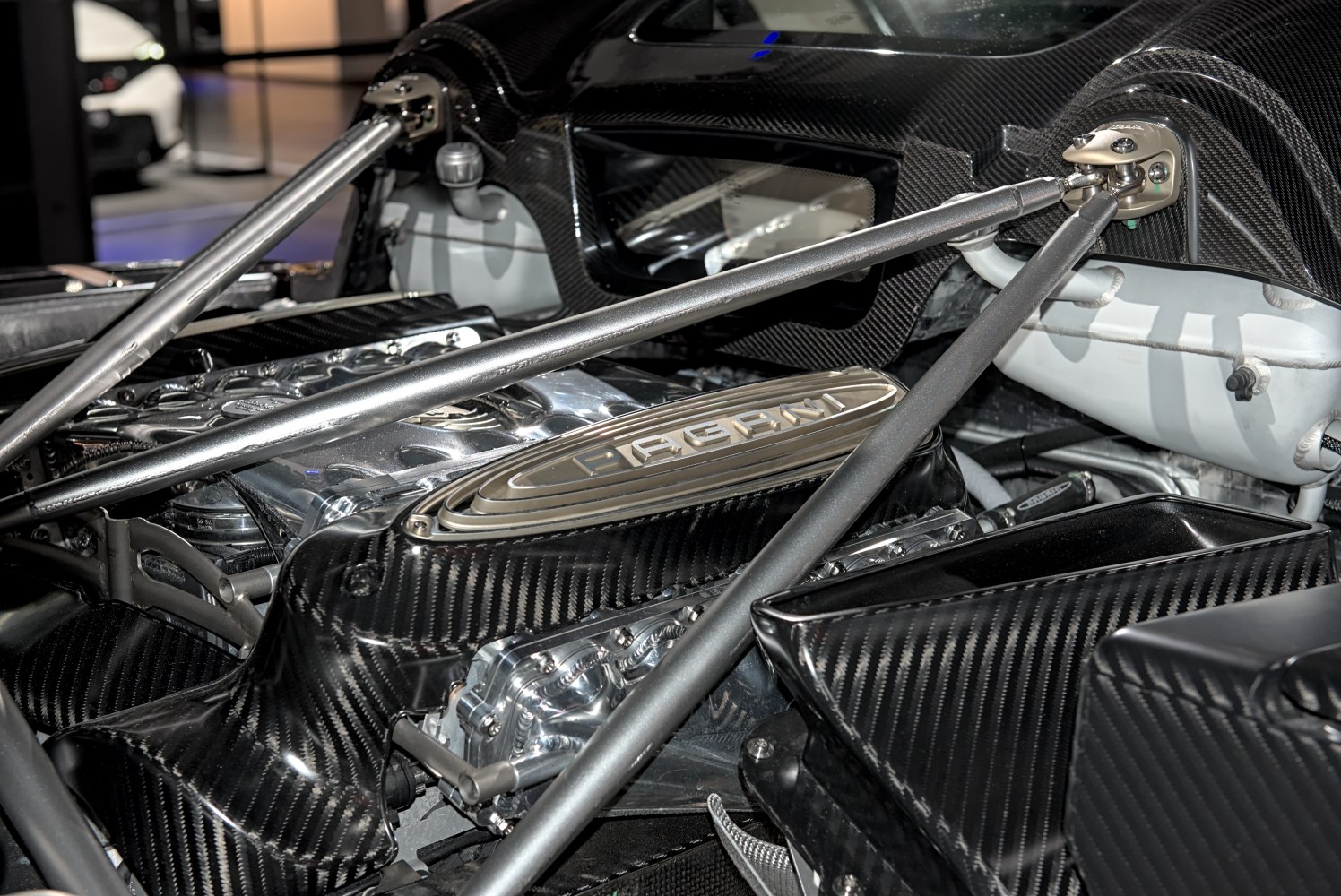 Carbon fiber engine bay with structural support bars and detailed engine components.