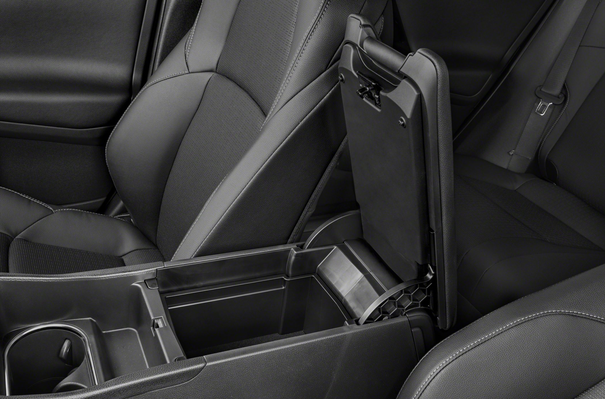 Open center console storage compartment with black front seats