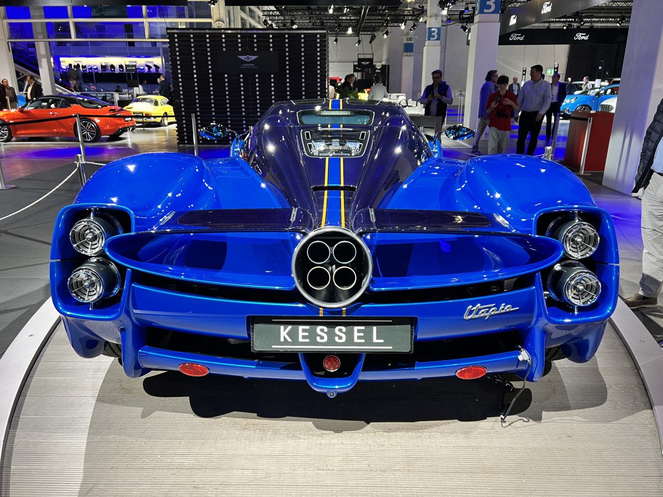 Rear view with quad exhaust pipes and aerodynamic fins in blue.
