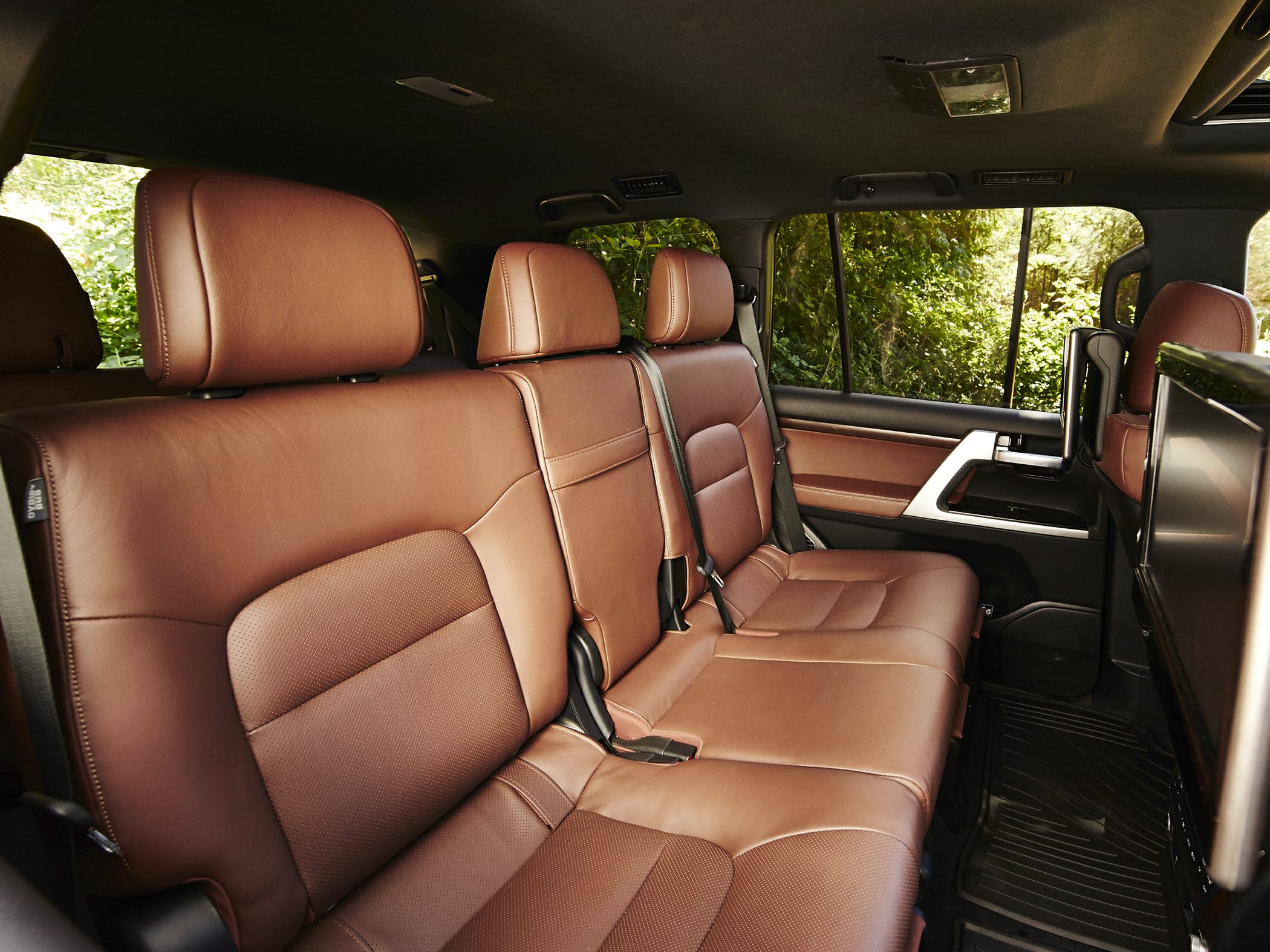 Brown leather rear seats with headrests and seatbelts