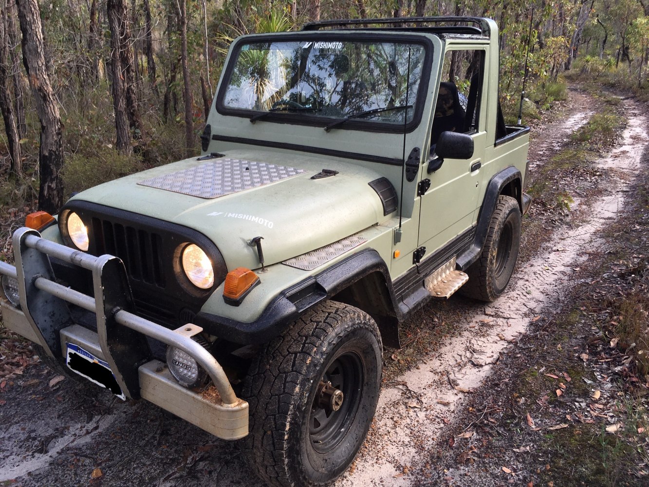 Off-road SUV with bull bar, hood protection, and rugged tires on dirt trail