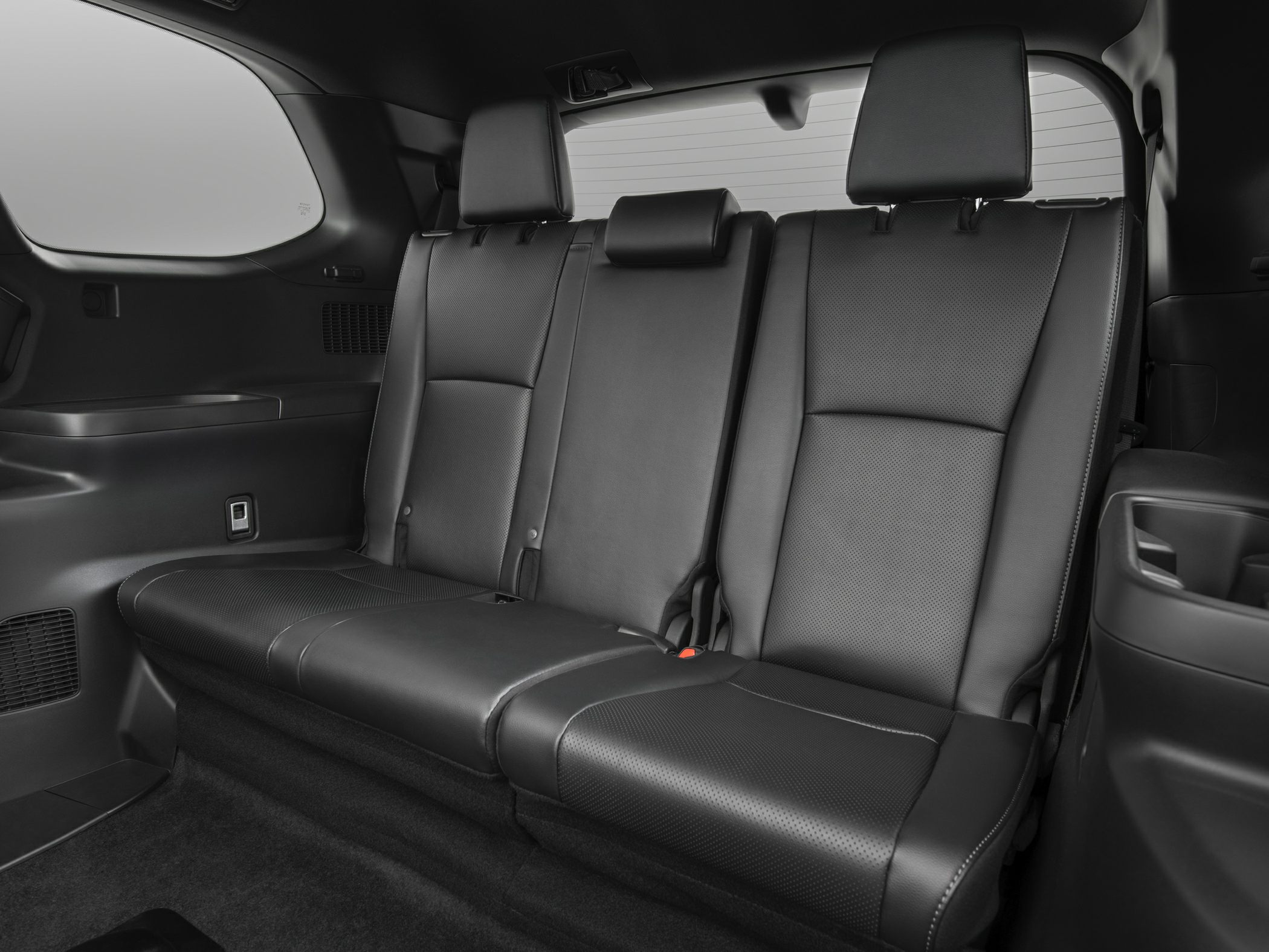 Spacious rear three-seat leather interior with headrests and side window.