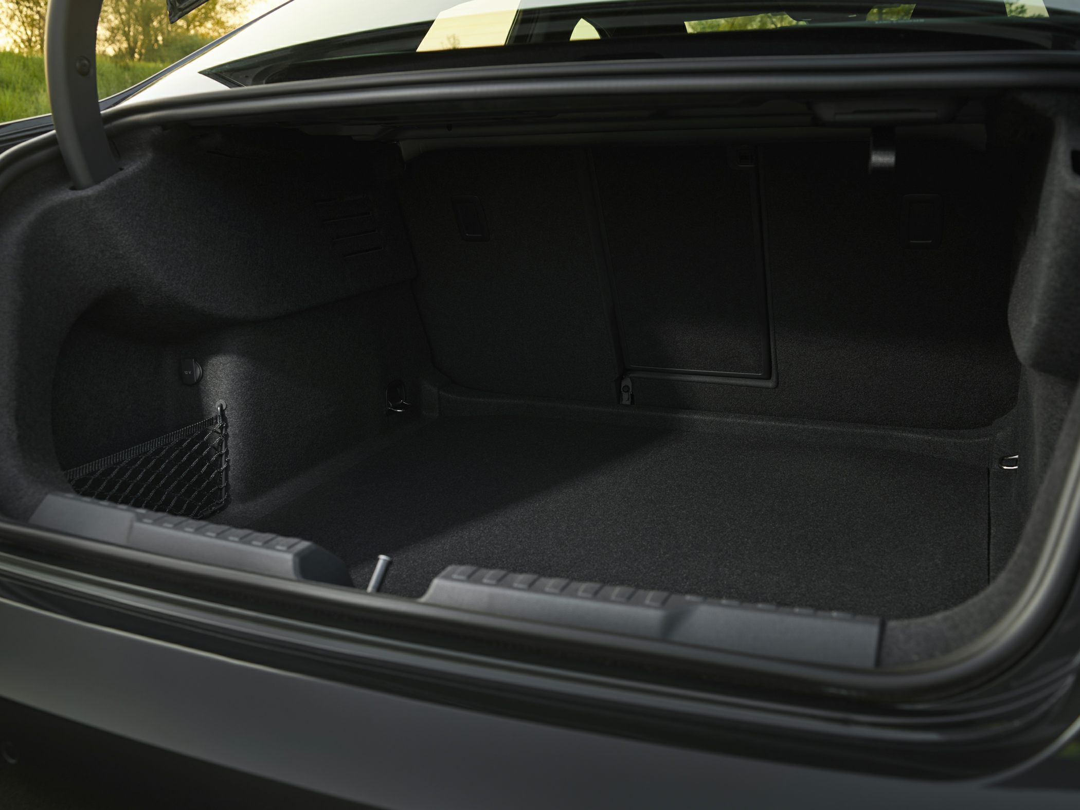 Spacious sedan trunk with cargo net and foldable rear access panel
