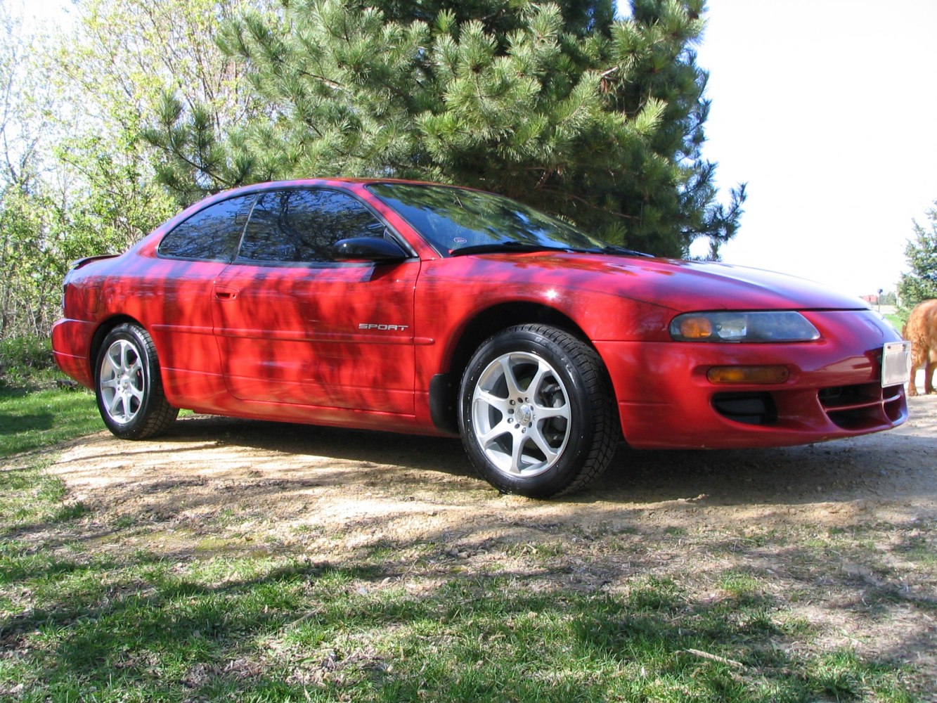 Sleek red sport coupe with alloy wheels and aerodynamic design.