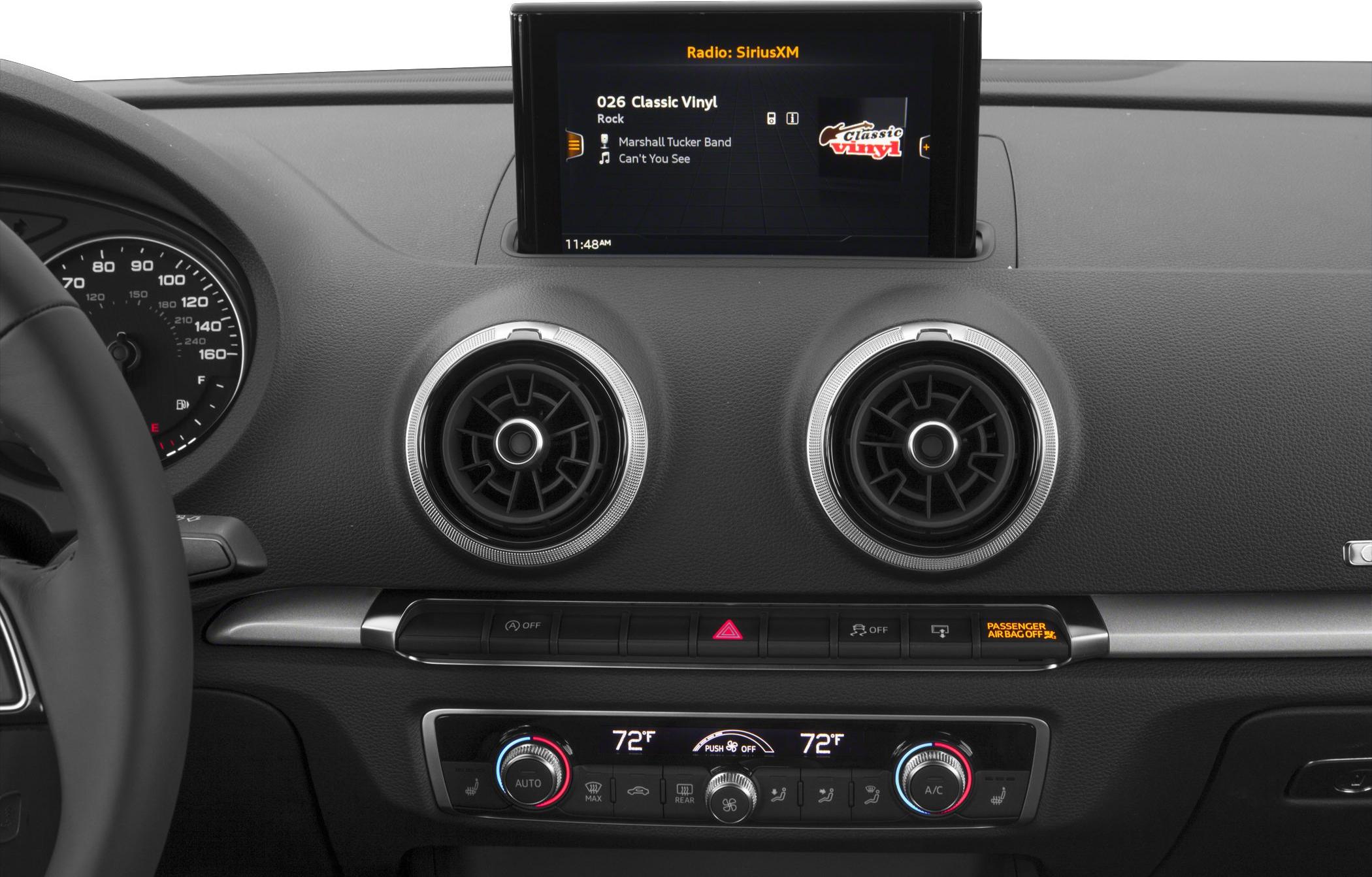 Dual round air vents with central infotainment screen on black dashboard