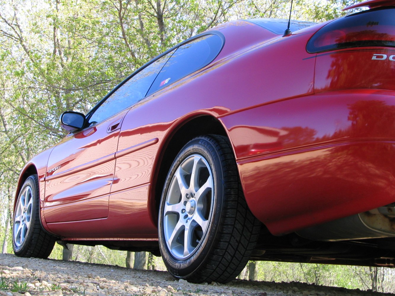 Rear side view of a sporty red coupe with alloy wheels