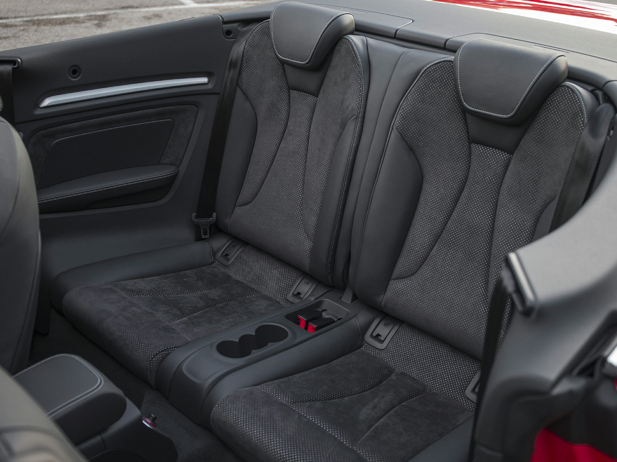 Rear seats with premium upholstery and central cup holders in a convertible interior