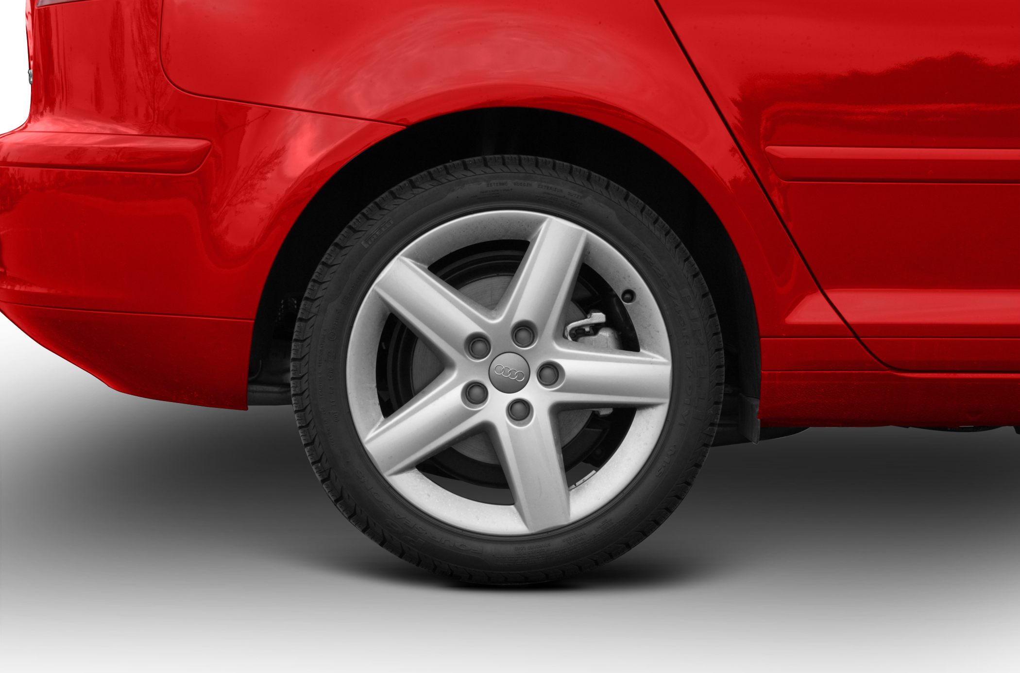 Five-spoke silver alloy rear wheel on red vehicle