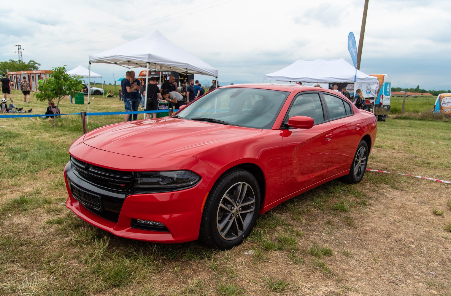 Red sedan with aggressive front grille and sporty alloy wheels