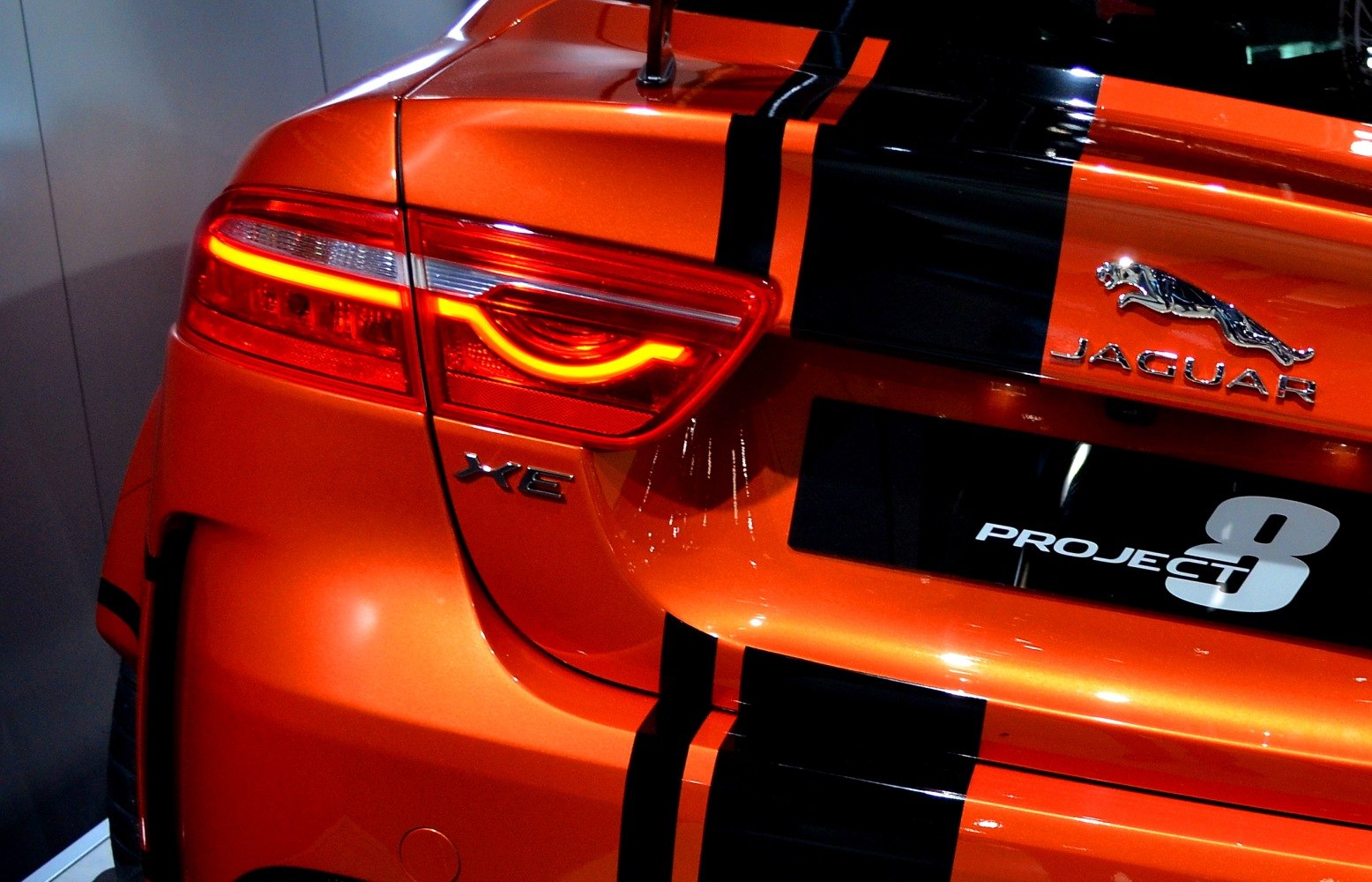 Rear LED tail light and badge with black racing stripes on orange body
