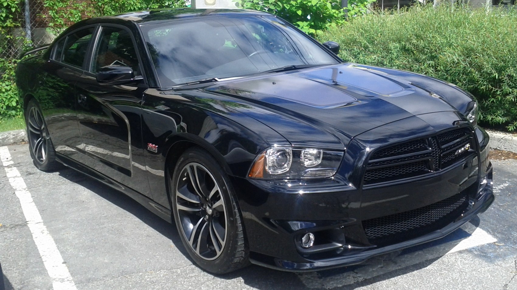 Black sporty sedan front and side profile with distinctive wheels