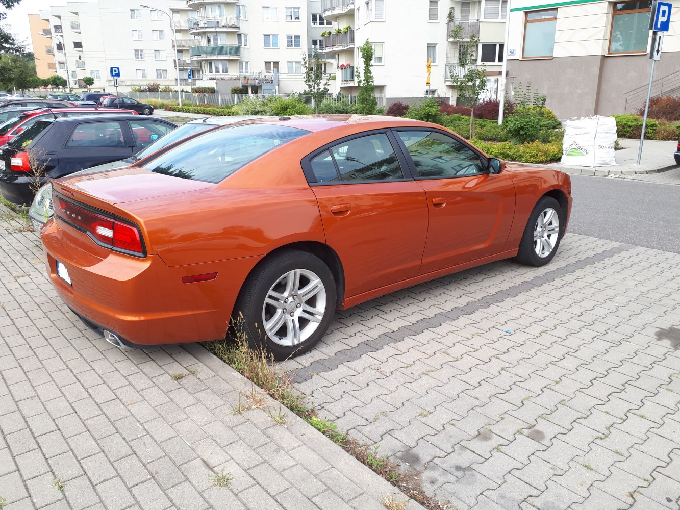 Orange sedan rear side view with distinct taillights and alloy wheels