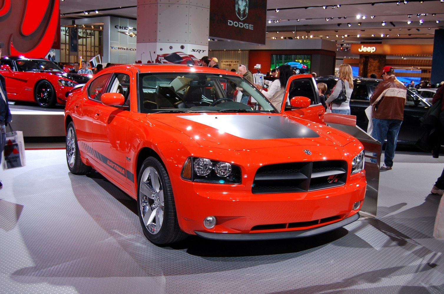 Red muscle sedan with Daytona stripes and black hood scoop.