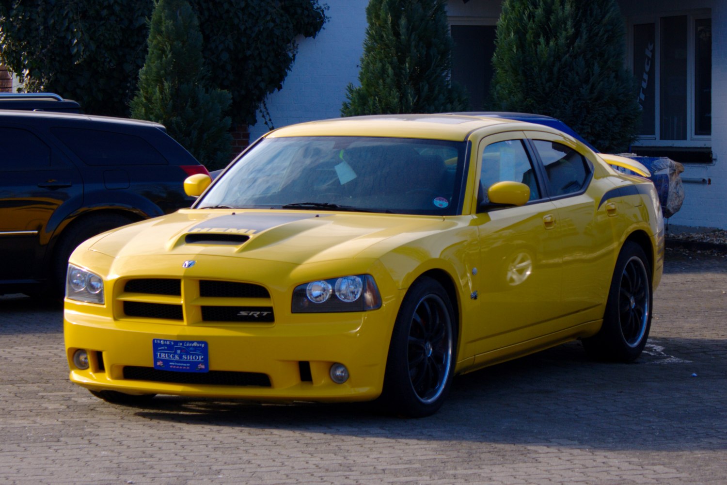Yellow Dodge Charger with hood scoop and black wheels