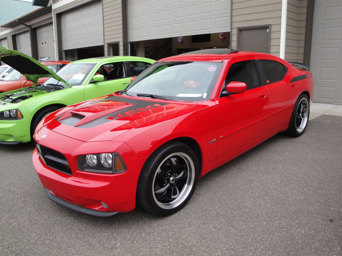Front side view of red Dodge Charger with HEMI hood and custom wheels