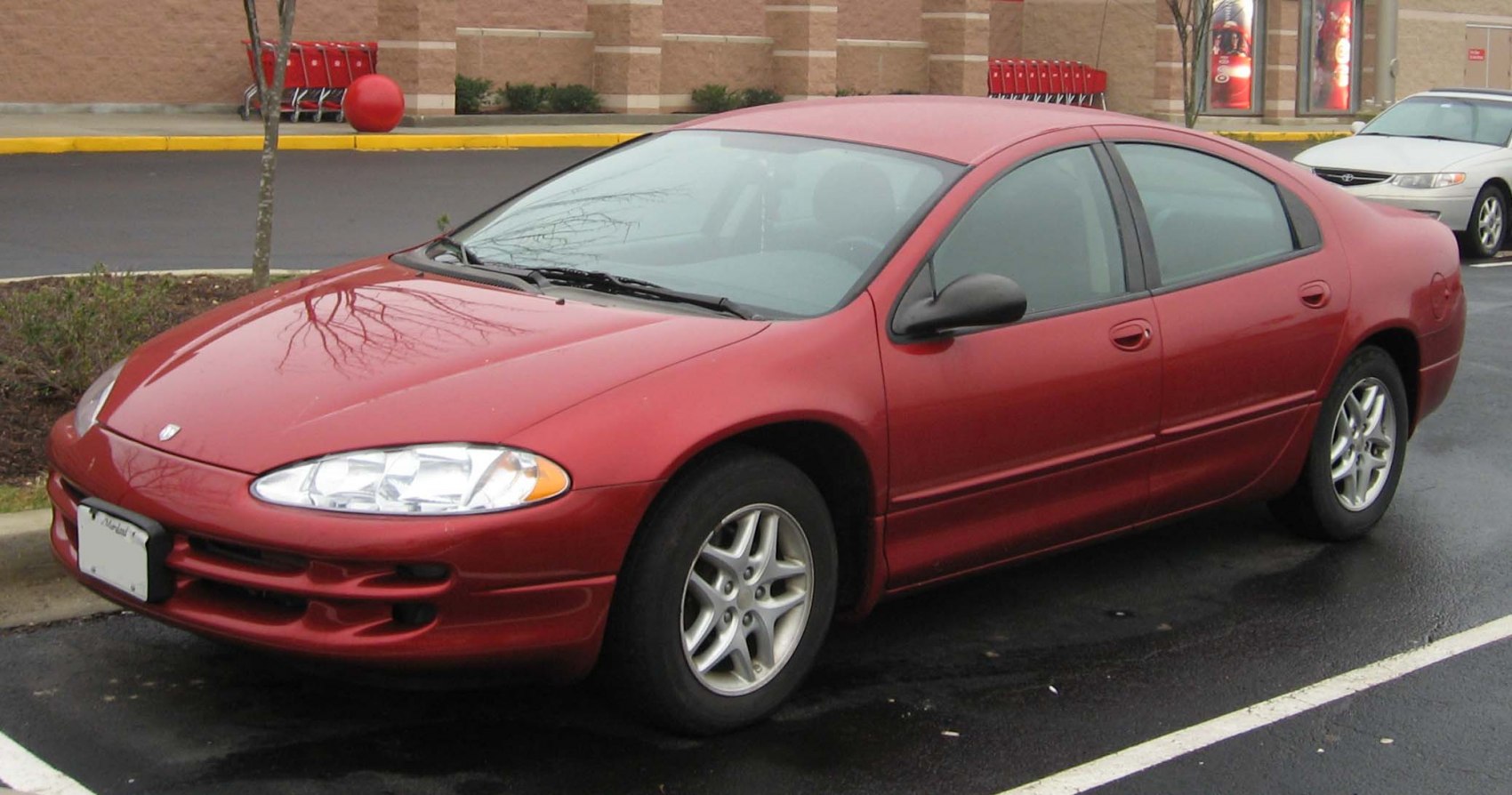 Red four-door sedan with aerodynamic shape and alloy wheels