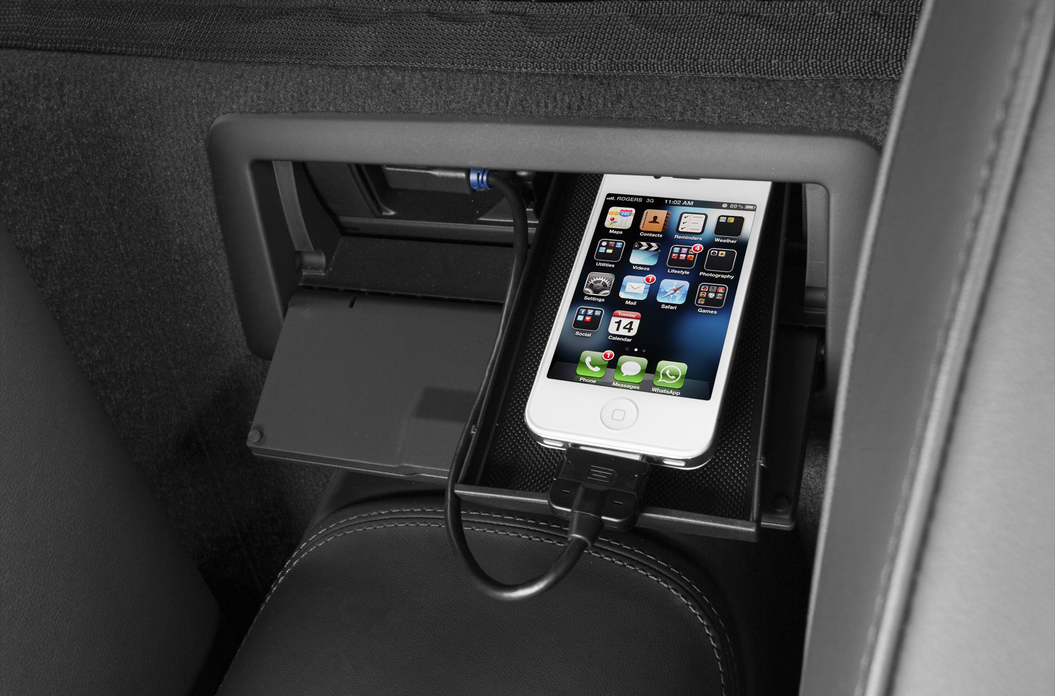 In-car USB charging dock with connected smartphone in premium sports car interior