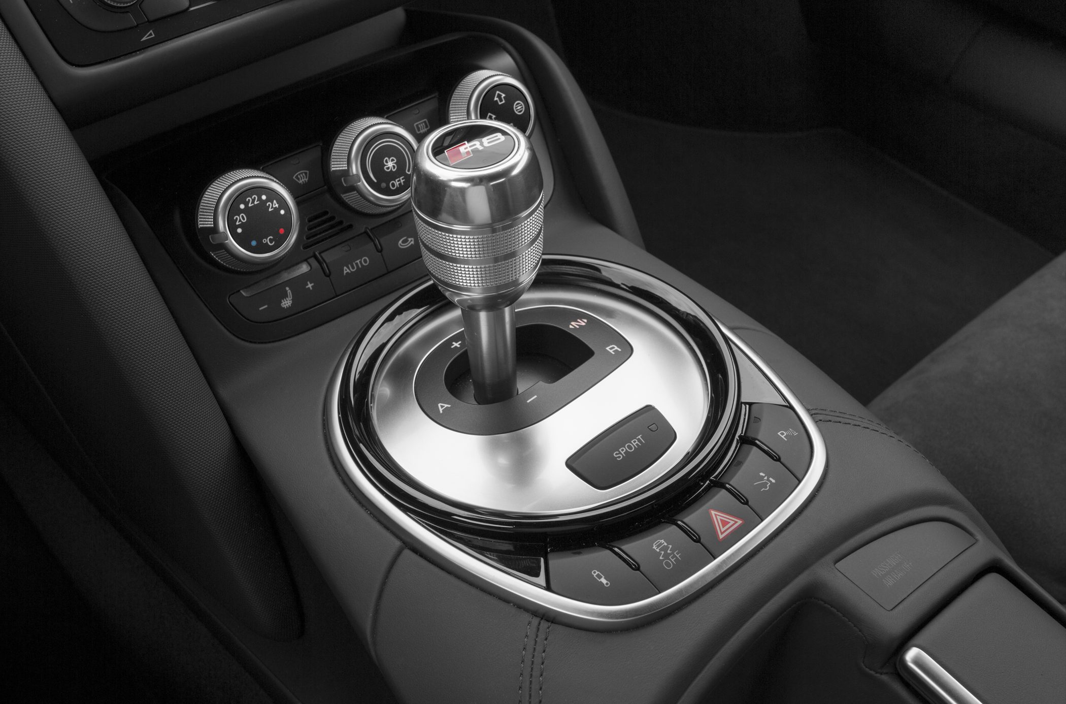 Close-up of a gear shift knob and climate control dials