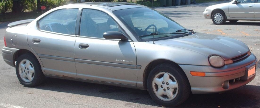 Silver compact sedan with rounded headlights and side profile.
