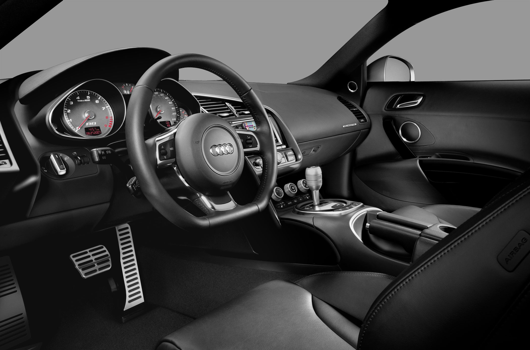Sport steering wheel, dual instrument gauges, and center console with gear shifter.