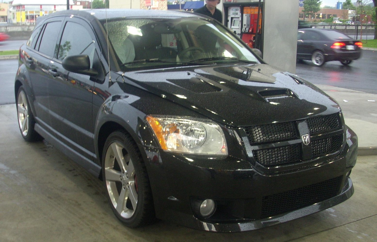 Black hatchback with hood vents and bold grille front side view