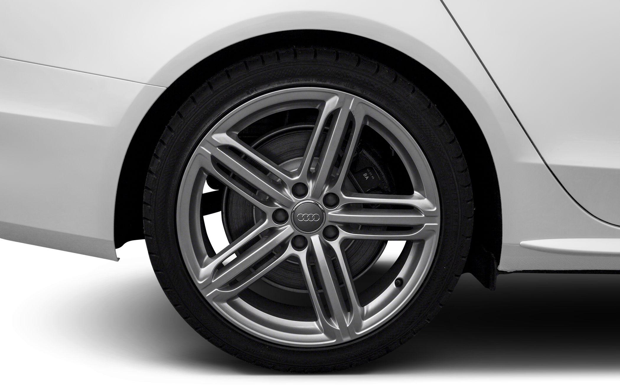 Close-up of alloy wheel and tire on a silver car panel.
