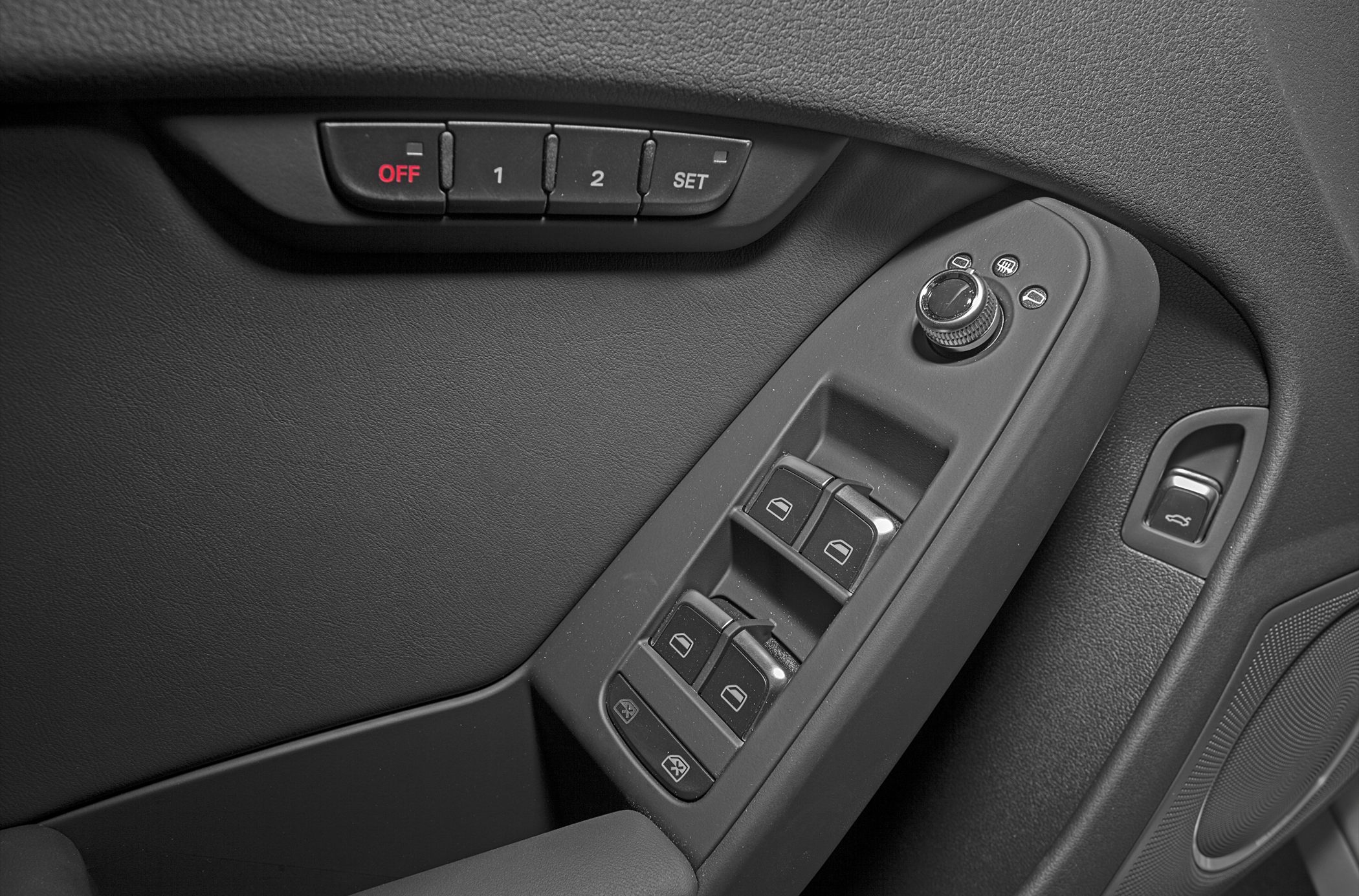 Power window controls, side mirror adjustment knob, and seat memory buttons on door panel