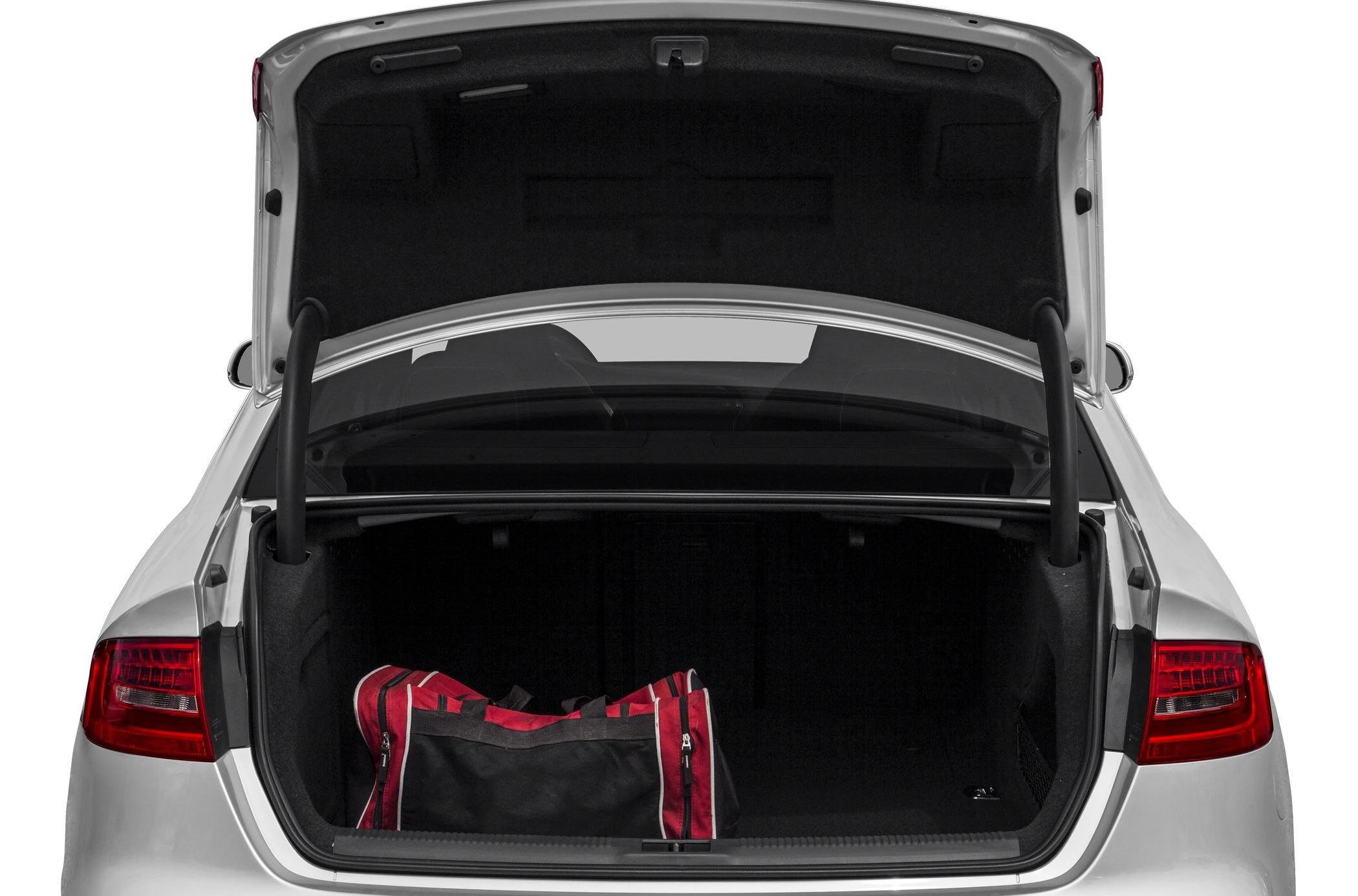 Open trunk of a sedan with a red and black duffel bag