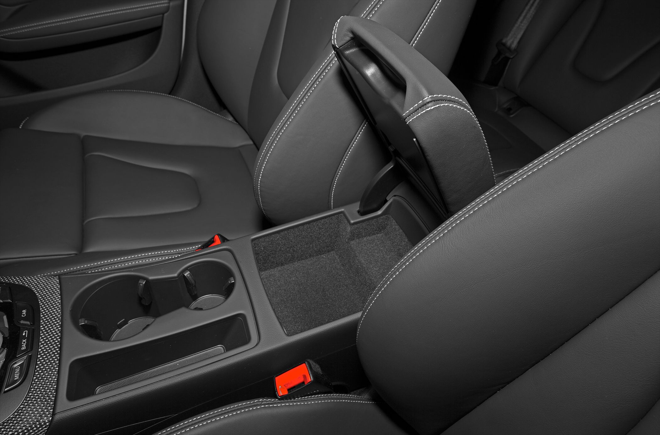 Center console with cupholders and leather armrest storage compartment.