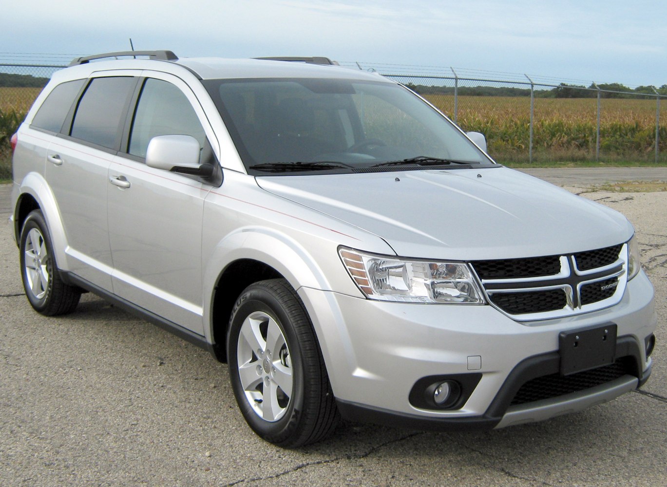 Silver midsize SUV with front side view and roof rails